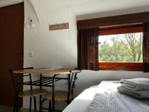 Selnica ob DraviGlamping PEC - All Inclusive light的一间卧室配有一张床、一张桌子和一个窗户。