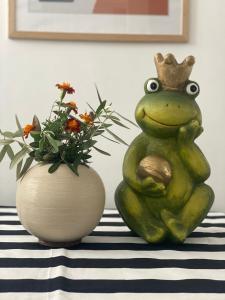 都拉斯Lola’s Apartment的花瓶旁戴着冠的青蛙