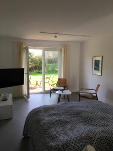 弗里克苏姆Nije Haven Bed & Breakfast的一间卧室配有一张床和一个带椅子的窗户。
