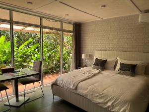 Elwa热带海滩度假村的一间卧室配有一张床、一张书桌和一个窗户。