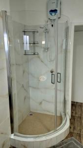 塔卡马卡Dovass Self Catering Apartments的浴室里设有玻璃门淋浴