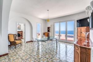马萨鲁布朗斯Villa Dafne的客厅设有玻璃桌,享有海景
