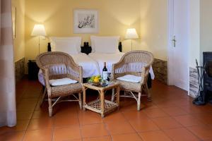 卡尼索Inn & Art Madeira的一间卧室配有一张带两把椅子和一张桌子的床。