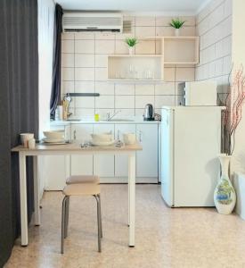 乌斯季卡缅诺戈尔斯克Уютная студия на Ауэзова 3的厨房配有桌子和冰箱