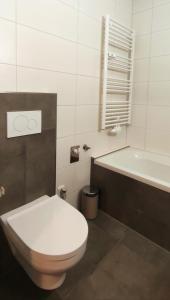 萨尔巴赫Alpenappartements Domicil的浴室配有卫生间、浴缸和水槽。