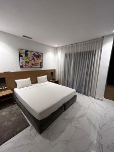 丹吉尔Twin Hotel Tanger的卧室设有一张白色大床和一扇窗户。