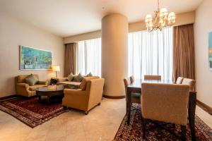 多哈JW Marriott Marquis City Center Doha的一间带桌子的客厅和一间餐厅