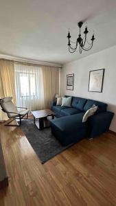 BuzăuGeorgiana’s central apartment的客厅配有蓝色的沙发和椅子