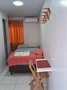 马瑙斯Alvorada Suite的一间小卧室,配有一张床和一张桌子