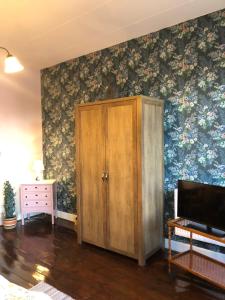 内克瑟Cafebrumman的一间设有橱柜和鲜花墙的房间