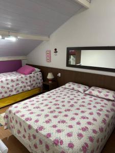 乌巴图巴MARA Maranduba! Apê c/ Piscina.的一间卧室设有两张带粉色床单的床和窗户。