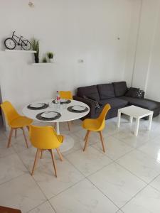 科托努Chez Fèmi, route des pêches的客厅配有桌子和黄色椅子