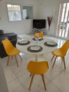 科托努Chez Fèmi, route des pêches的客厅配有桌子和黄色椅子