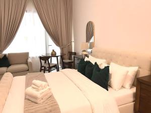 Al QurayyahClassy Studio in Masdar City的一间带白色大床的卧室和一间客厅