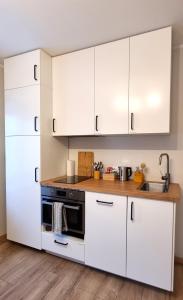 塔林Entire Apartment + 2 Rooms + Self Check-in的厨房配有白色橱柜和黑烤箱。
