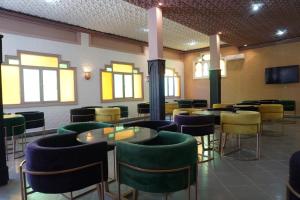 瓦尔扎扎特Hotel Warda的餐厅设有绿色和黄色的椅子和桌子