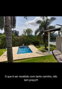 阿蒂巴亚Chácara Volare em Atibaia, exclusiva, condomínio fechado的棕榈树庭院中的游泳池