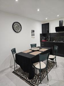 莫尔比耶Appartement T2 bis à morbier的餐桌、椅子和墙上的时钟
