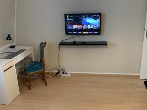 Annappeschambre cosy的客房设有书桌和墙上的电视