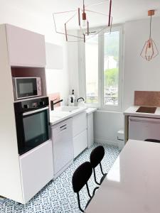 勒蒙多尔Appartement Rose velours的厨房配有白色家电和桌椅