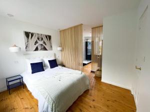 勒蒙多尔Appartement Rose velours的卧室配有带蓝色枕头的大型白色床