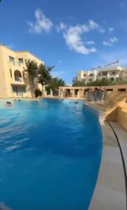 哈马马特Appartement résidence Port yasmine hammamet的蓝色海水大型游泳池