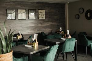 科普日夫尼采塔特拉因特酒店的用餐室配有桌子和绿色椅子