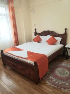 内罗毕JVhomes2bedroom-Ndemi gardens的一间卧室配有带白色床单和橙色枕头的床。