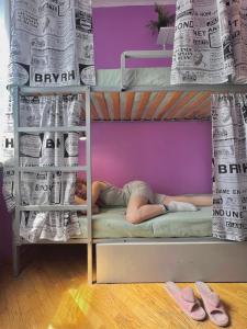 基辅Pechersky Hostel的躺在双层床上阅读报纸的人