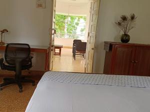 艾哈迈达巴德Srinekatan Heritage Villa Homestay的一间卧室配有一张床、一张桌子和一把椅子