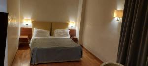 Solofra索罗法皇宫度假酒店的配有两张枕头的床的酒店客房