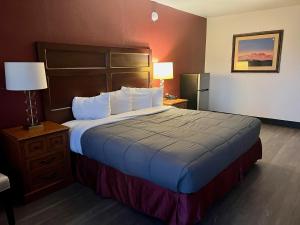梅萨Extend -a -Suites Mesa的酒店客房设有一张大床和一盏灯。