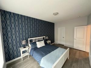 沃恩Modern Townhouse, Vaughan, Ontario, Canada的一间卧室设有一张床和蓝色的墙壁