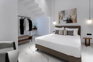雅典New Villa In Downtown的一间白色卧室,配有一张床和一些衣架