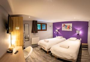 新城勒鲁瓦Résidence Artemis Paris Orly Aéroport的紫色墙壁的酒店客房内的两张床