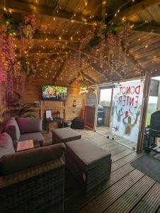 德里门FINN VILLAGE - Loch Lomond Sunset Glamping Pod - Private Ofuro HOT TUB的带沙发的客厅和天花板上的电视