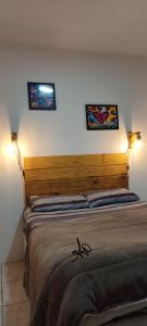 阿雷格里港Apto Humaitá的卧室配有一张墙上有两张照片的床。