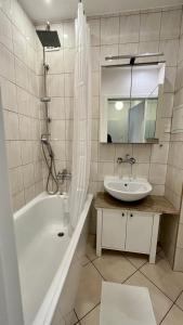 华沙Warszawa Krucza Pokoje的带浴缸、水槽和镜子的浴室
