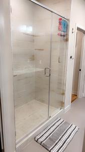 休斯顿Luxe Mid-Downtown apartment的浴室设有玻璃淋浴间,铺着地毯