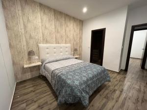乌夫里克Casa rural Huertas de Ubrique的一间卧室配有一张床,铺有木地板