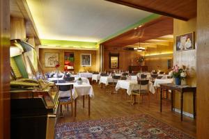 拉沃尔戈蒂凡提酒店的一间设有白色桌椅和三角钢琴的餐厅