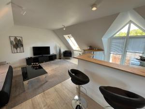 普劳恩attraktives Appartement im Stadtzentrum Plauen Balkon Lift的客厅设有2张凳子和电视