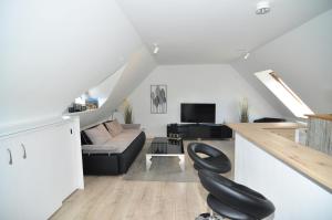 普劳恩attraktives Appartement im Stadtzentrum Plauen Balkon Lift的带沙发的客厅内的一张黑椅