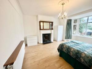 Catford4 Bed house in Daneby Road,SE6的一间卧室配有一张床和一个壁炉