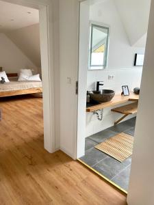 哈嫩克利博克斯维斯Harzpur Lodge - Pure Entspannung in purer Natur的一间带水槽的浴室和一张位于客房内的床