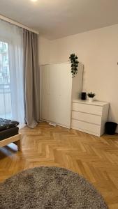 华沙Warszawa Krucza Pokoje的客厅铺有木地板,配有白色橱柜。