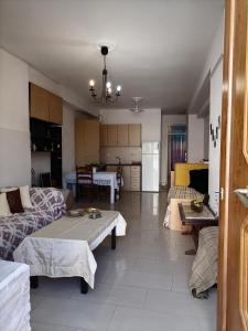米蒂利尼PERGAMOS APARTMENTS的一间带两张沙发的客厅和一间厨房