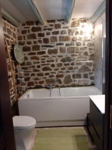 卡尔派尼西翁Fairytale Stone House的浴室配有白色浴缸和石墙