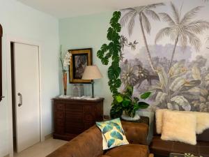库列拉Nacaren Cullera的带沙发和棕榈树壁画的客厅