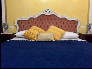 威尼斯CA' DI LUNA VENEZIA的一间卧室配有蓝色的床和黄色枕头
